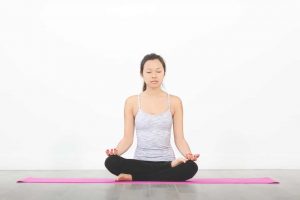 woman on yoga mat meditating