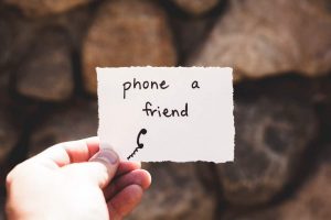 hand holding a card that says phone a friend
