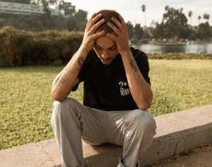 worried man outside with head in hands
